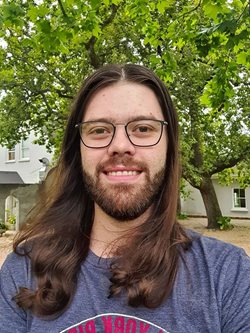 A person with long hair and glassesDescription automatically generated with medium confidence
