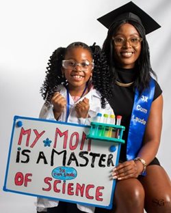 A person and a child holding a signDescription automatically generated