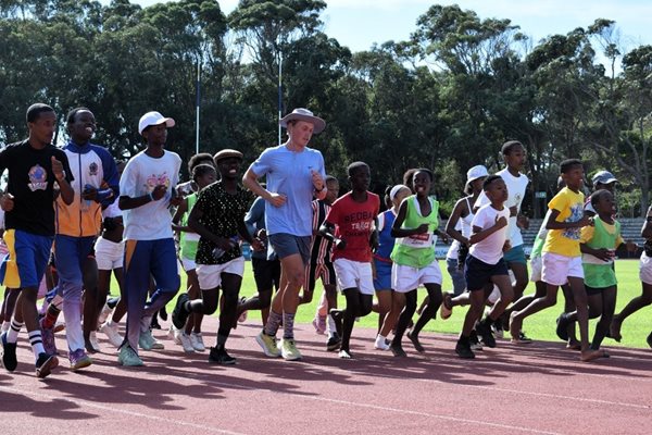 A group of people running on a trackDescription automatically generated